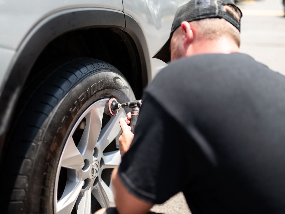 Majeski Wheel Restoration technician sanding and prepping a Lexus alloy wheel for repair on-site in Alexandria, VA