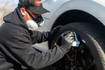 worker cleaning wheel on site